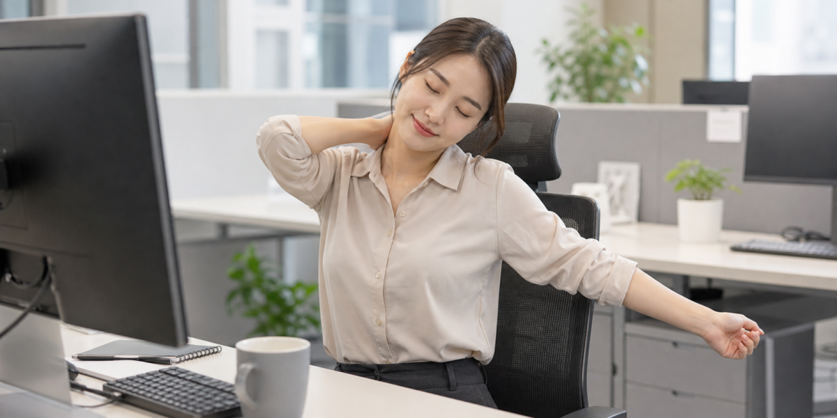 책상 앞에서 목과 어깨를 스트레칭하는 모습
