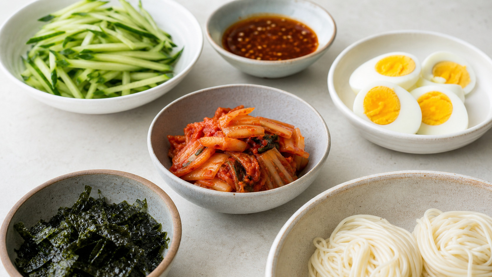 채 썬 오이, 삶은 달걀, 김치, 양념장을 작은 그릇에 미리 준비한 모습
