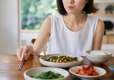 여름 식탁에서 채소와 달걀을 곁들인 국수를 천천히 먹는 한국인