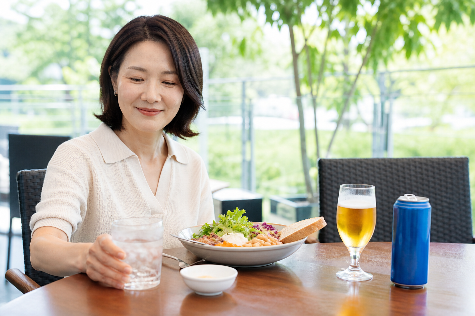 여름 야외 식탁에서 술 대신 물을 선택하는 한국인 중년 여성