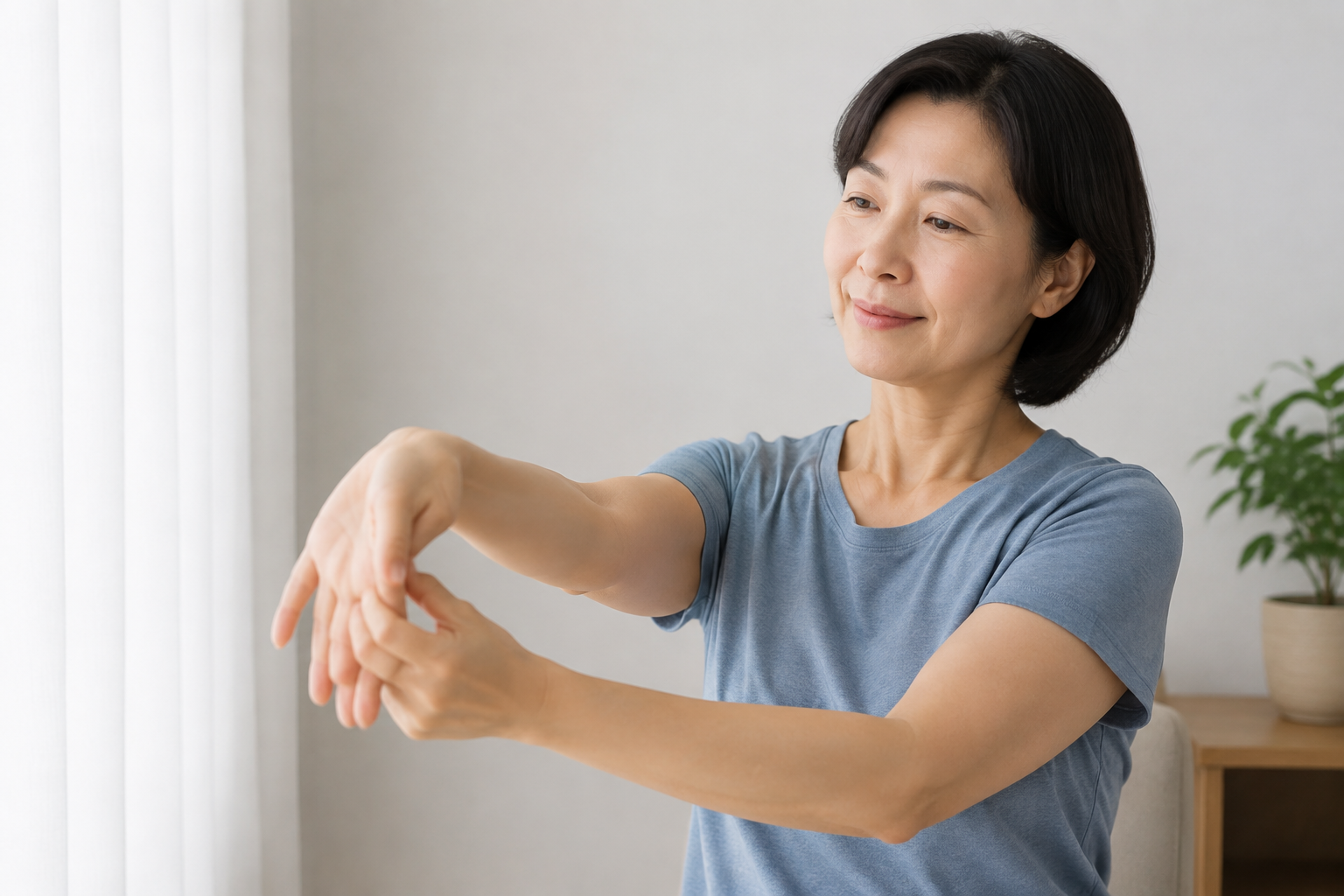 통증 없는 범위에서 손목을 부드럽게 스트레칭하는 한국인 여성