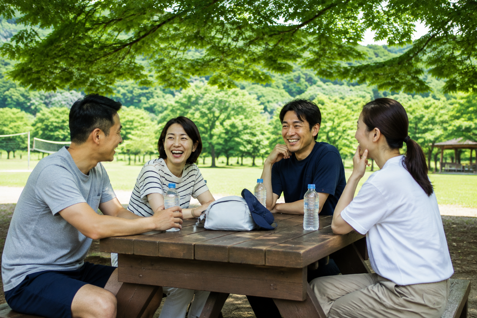 나무 그늘 아래 물병을 두고 대화하는 성인 네 명